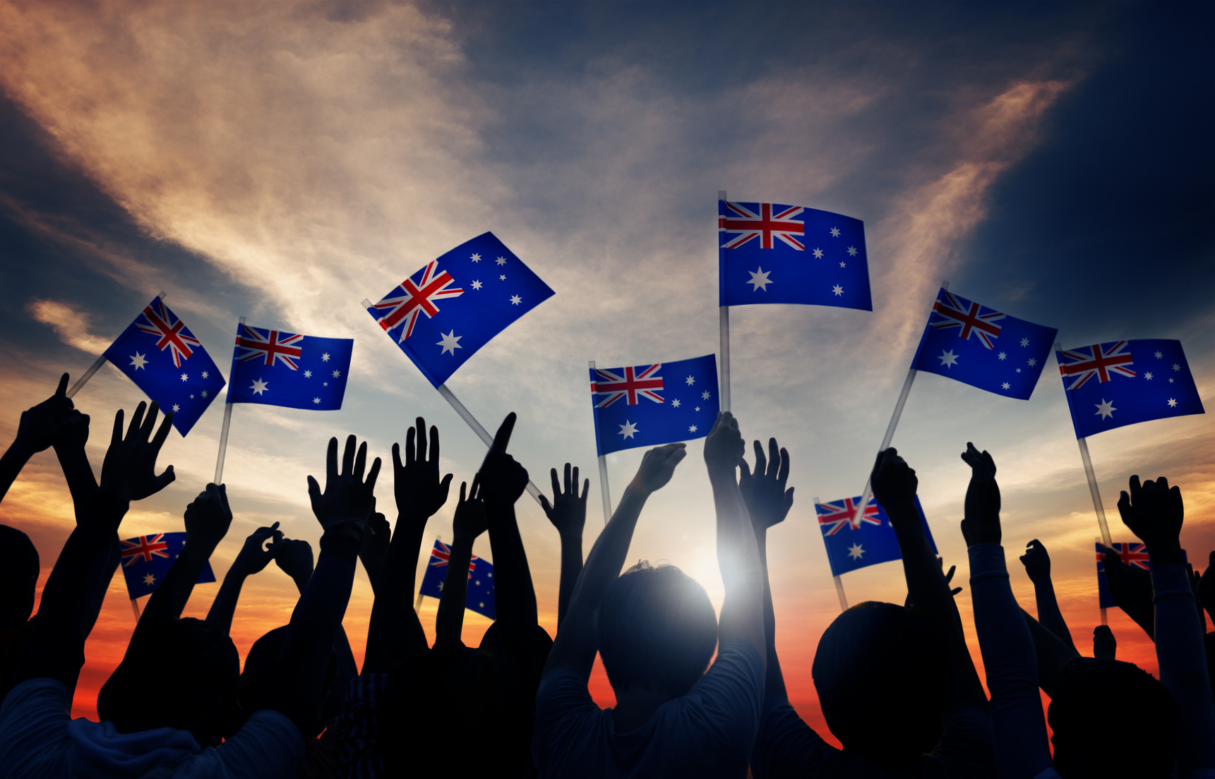 Group of People Waving Australian Flags in Back Lit Littlegate Publishing